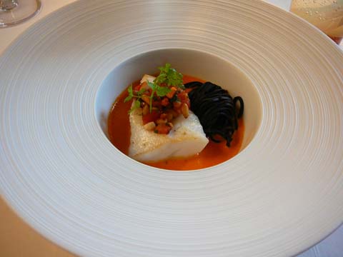 Le filet de Saint-Pierre poêlé aux spaghetti à l'encre, émulsion de pimentos au bouillon de calamar Le filet de Saint-Pierre poêlé aux spaghetti à l'encre, émulsion de pimentos au bouillon de calamar